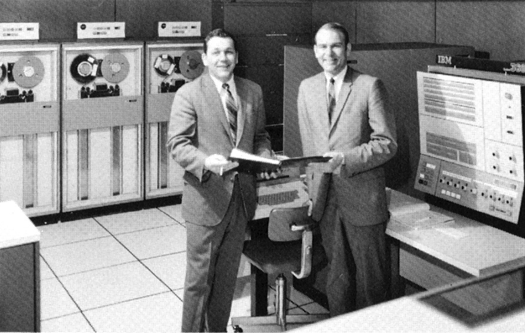 Illinois Mutual employees stand next to the Company’s first mainframe computer.