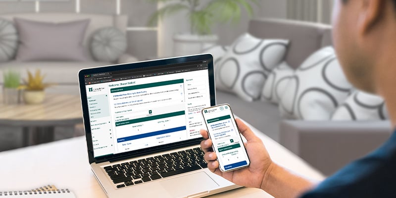 person looking at phone and laptop screens