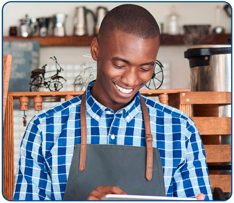 smiling young small business owner looking at tablet
