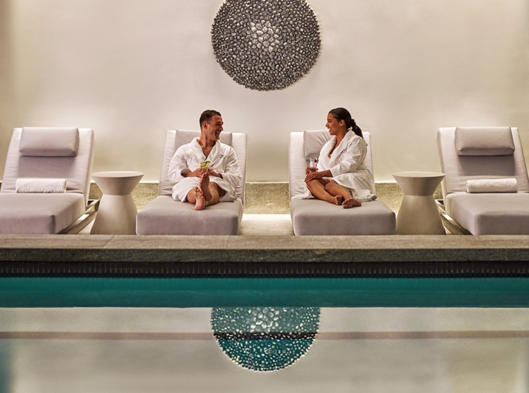 image of a male and female sitting by the pool