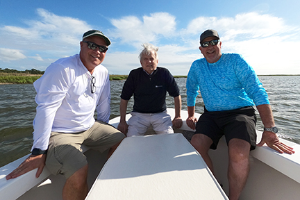 fishermen posing for a photo on the front of the boat