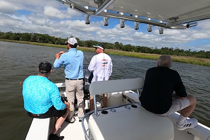 group of fishermen fishing off the back of a boat