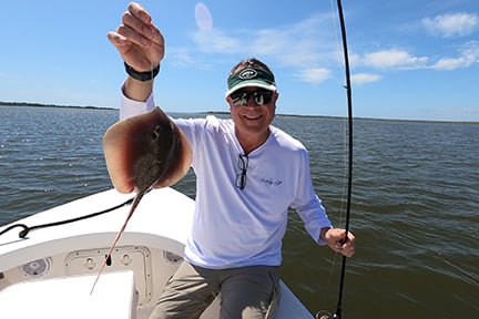 fishermen holding a stingray he caught
