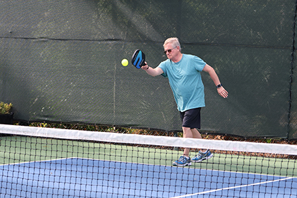 pickleball player hitting the ball back