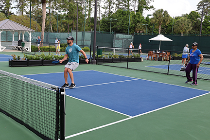 action shot of a doubles pickleball game in progress