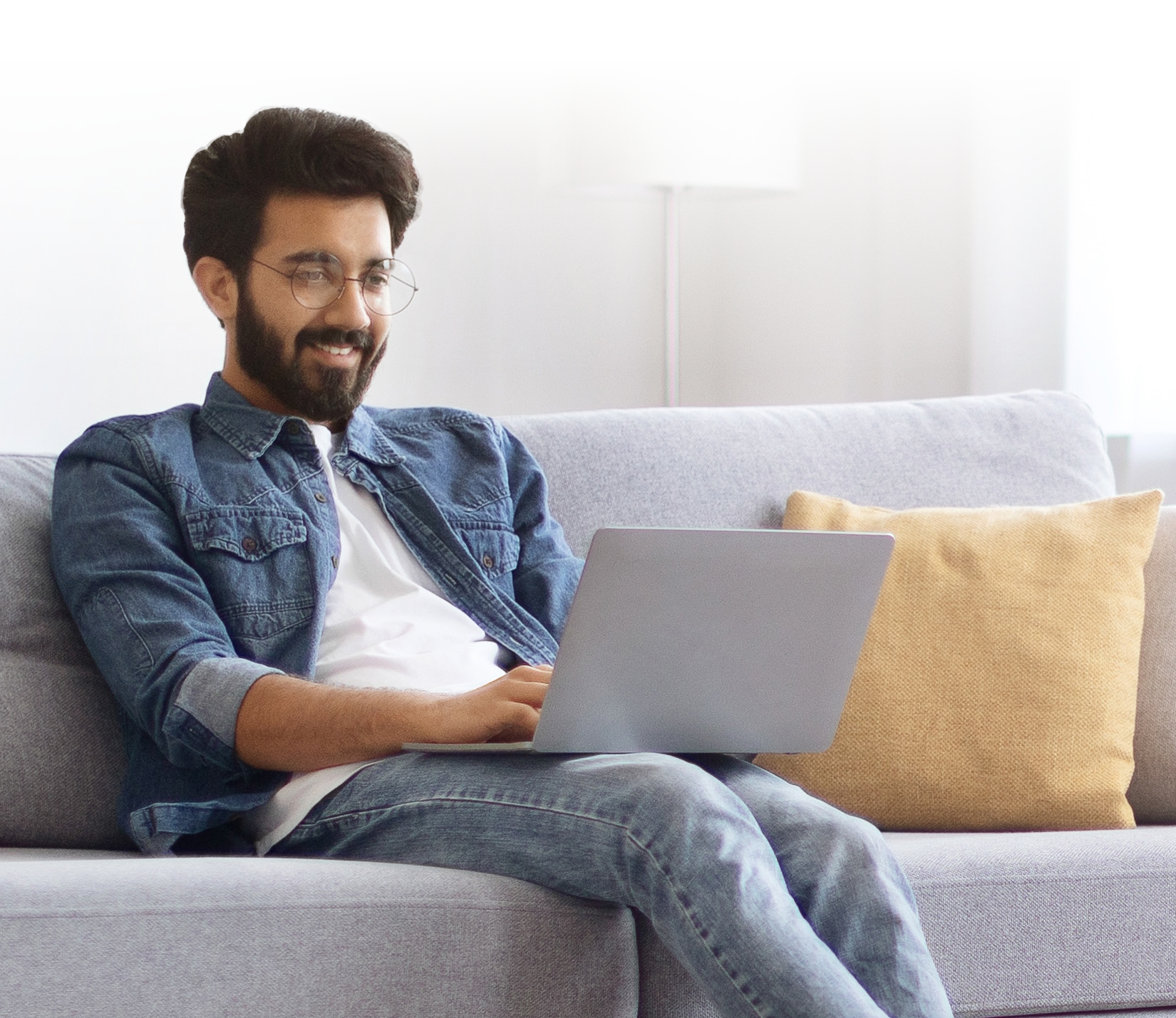 worksite-image image of policy holder siting on a couch with a laptop in there lap