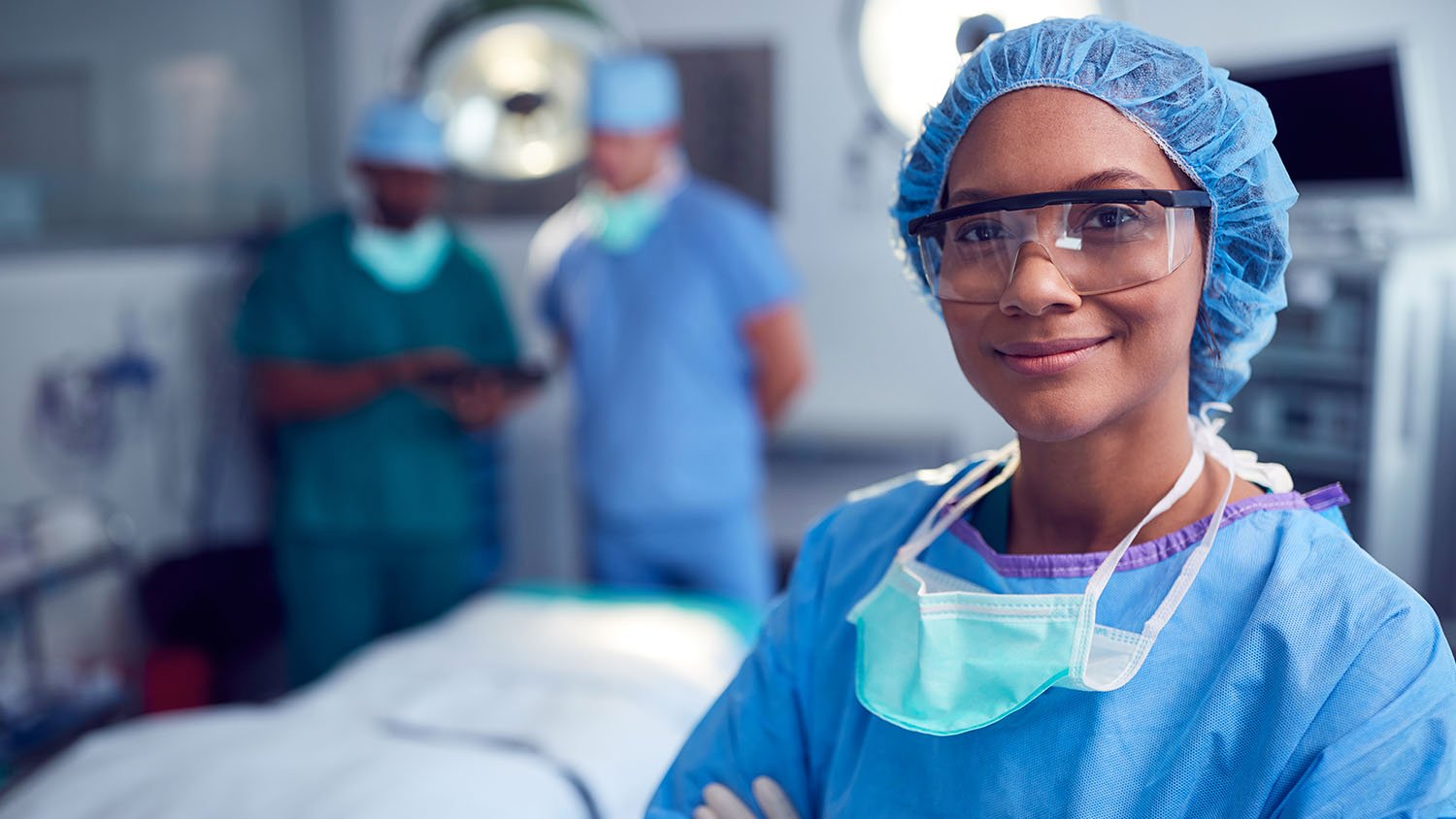 photo of a nurse in scrubs with 2 more in the background