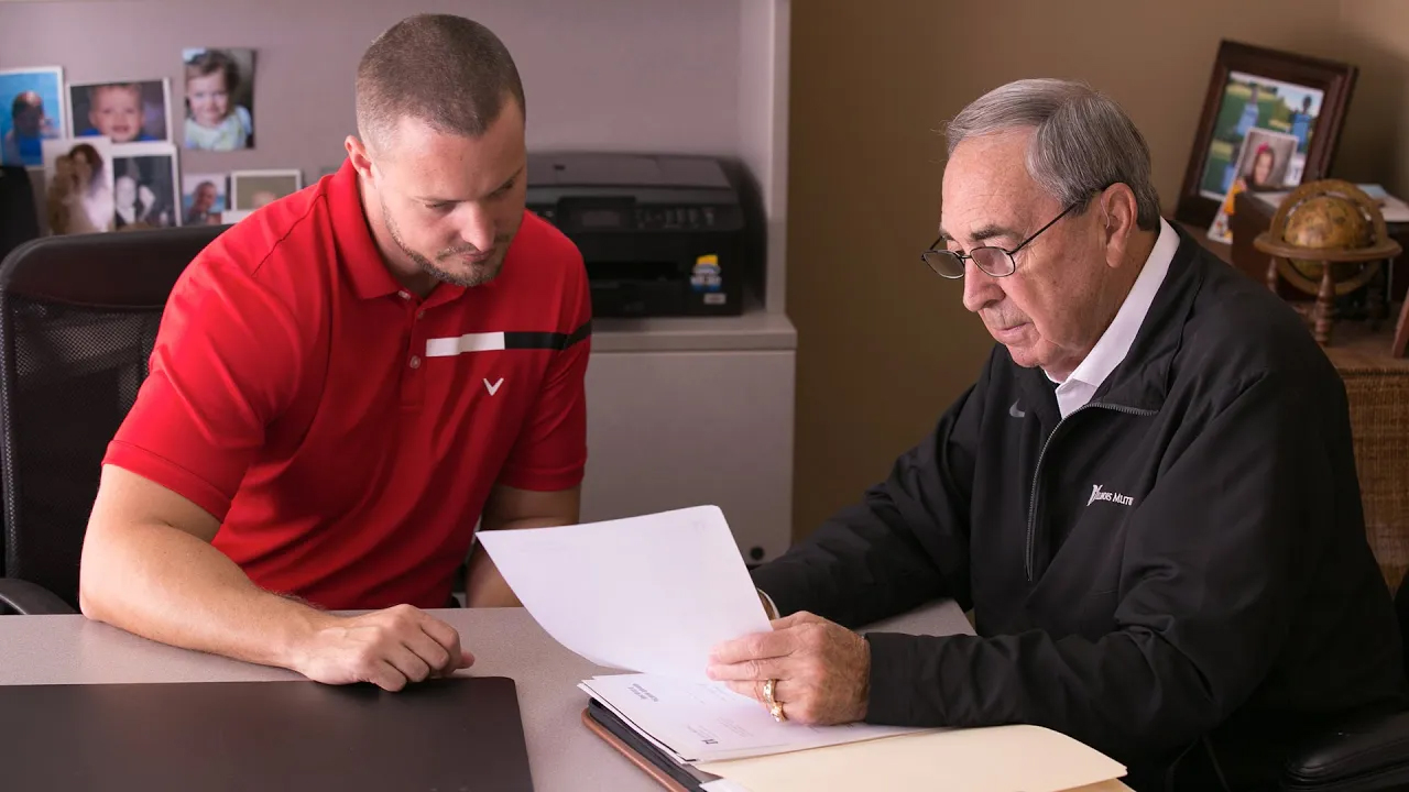 insurance agent with client looking over paperwork
