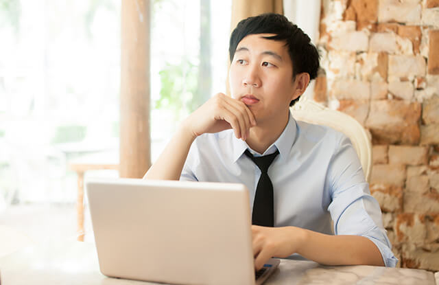 young man on laptop thinking