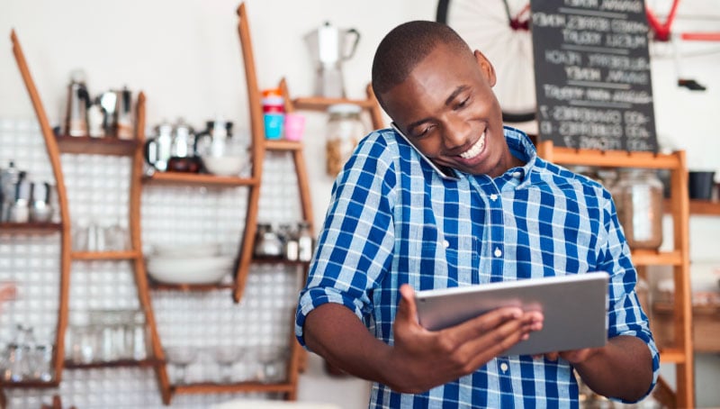 thumbnail image of a small business owner on the phone and tablet