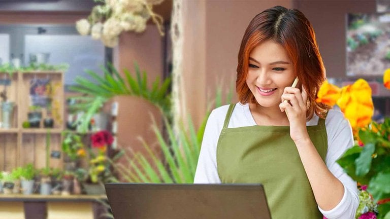 small business owner on her laptop and cell phone