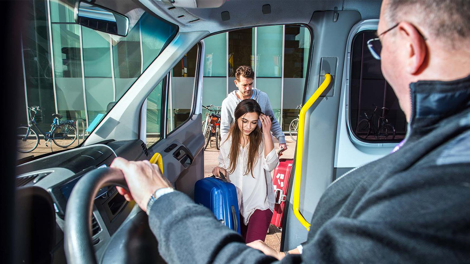 Bus driver picking up a man and woman