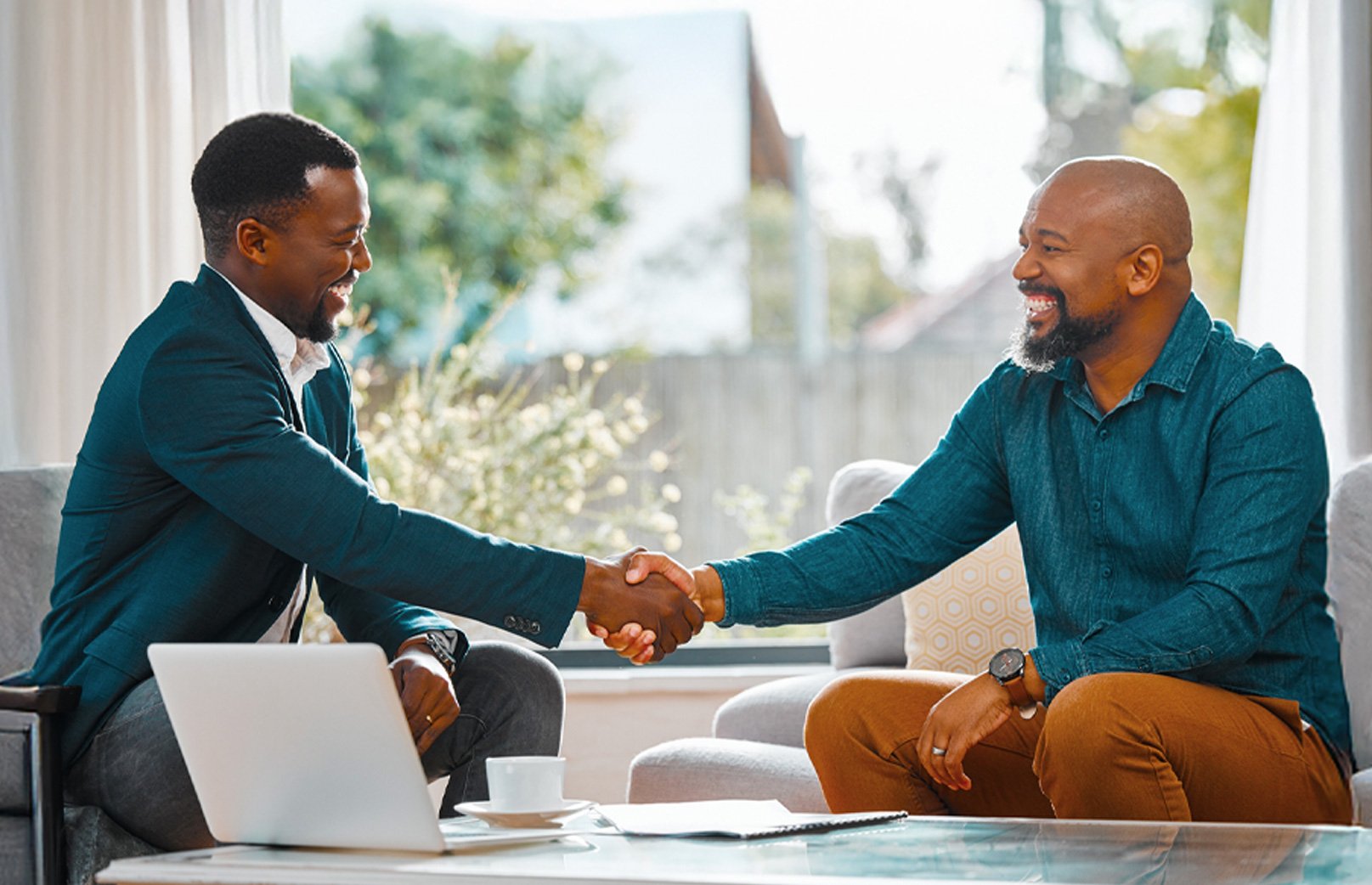 insurance agent shaking hands and smiling with his client