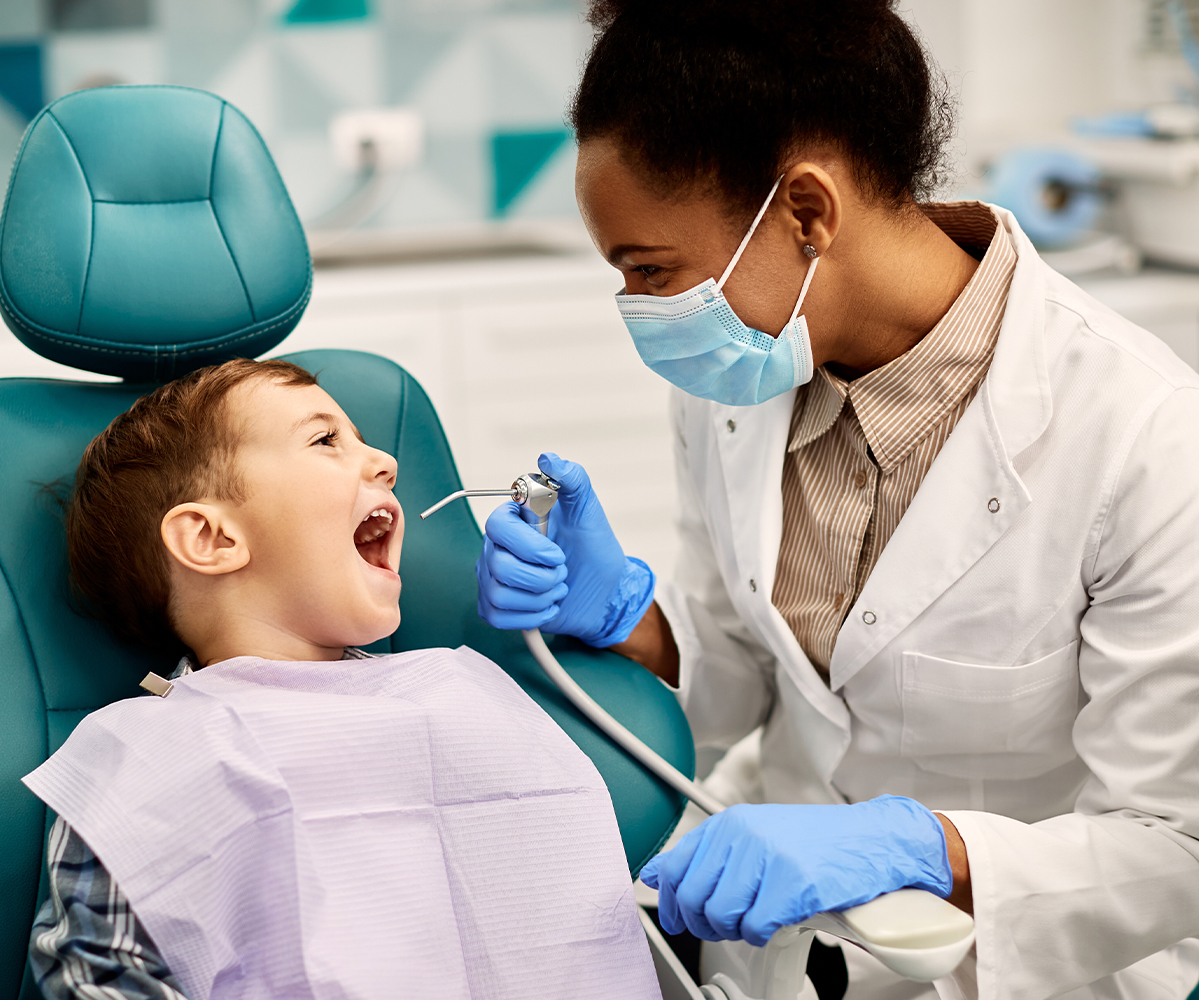 image of a dental hygienist cleaning a young boys teeth